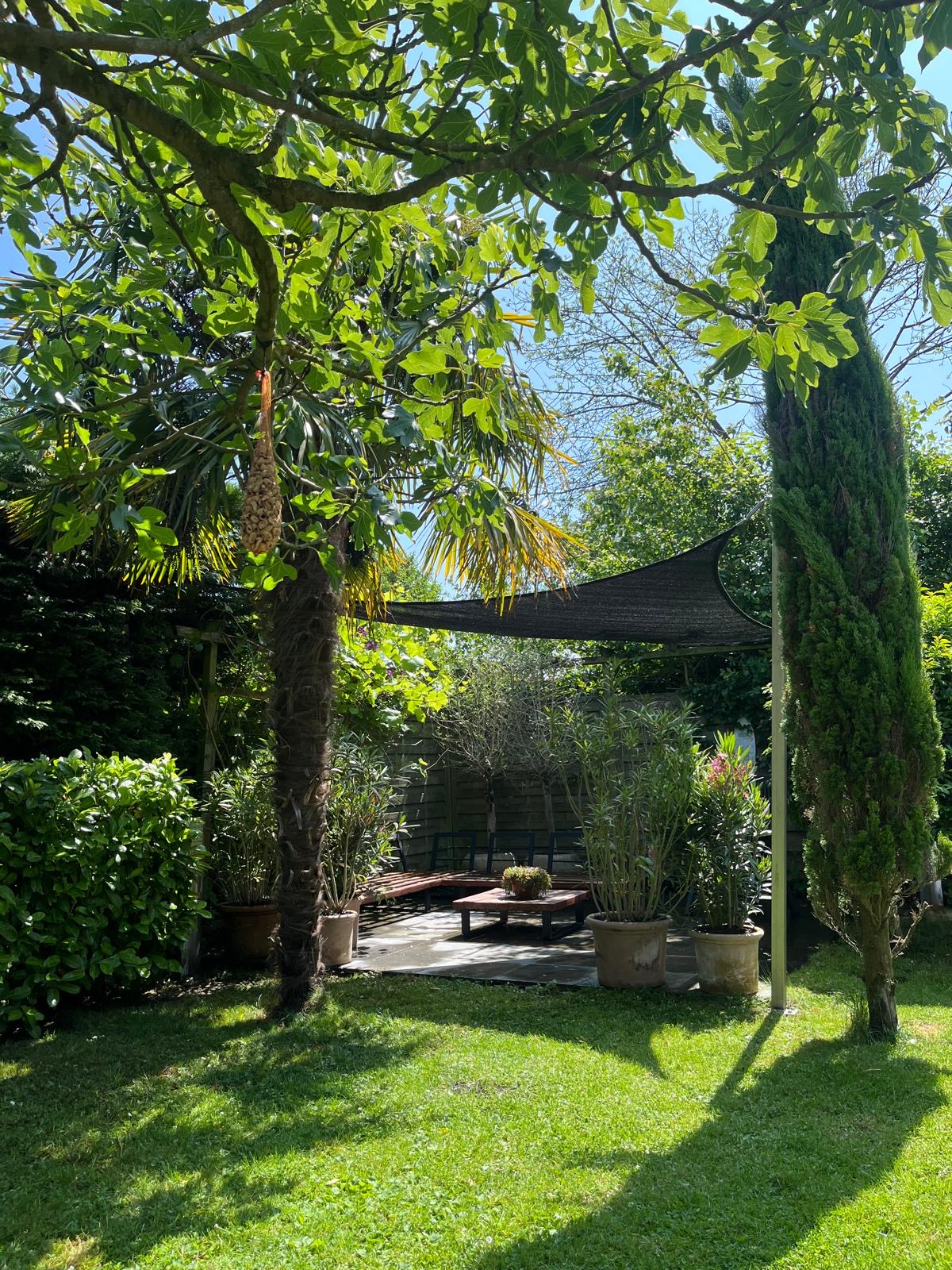 Overdekt terras tussen het groen van de tuin